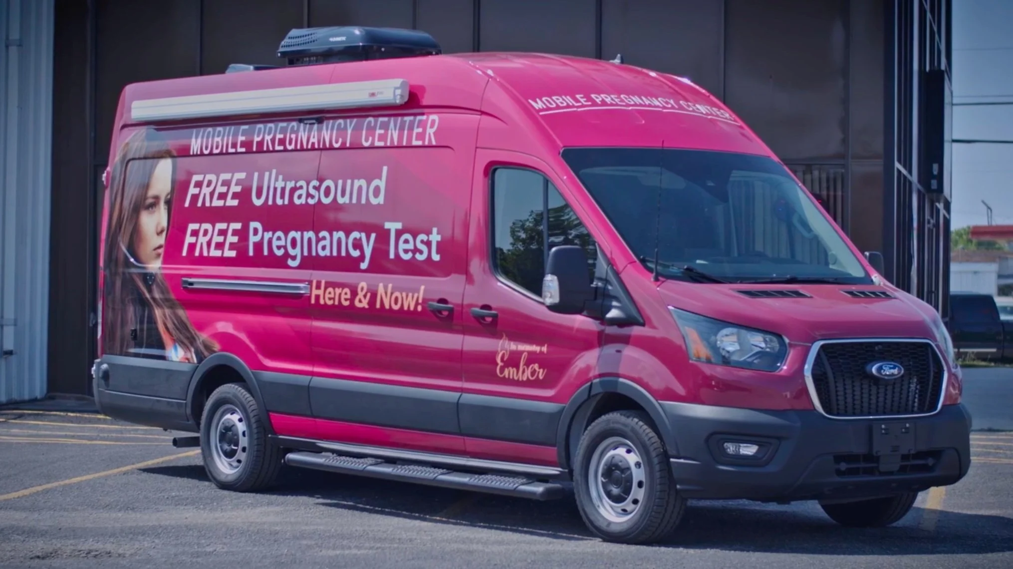 A Vans for Life mobile pregnancy center van parked outside a facility